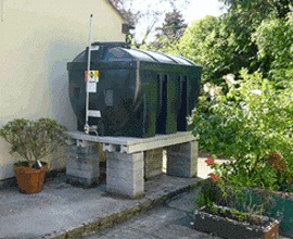 Bunded oil tank next to a house.