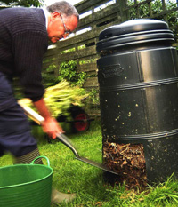 Man getting compost from a compost bin.
