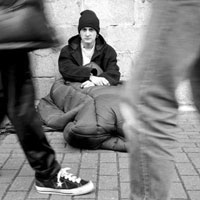 Homeless man in a sleeping bag on the street.